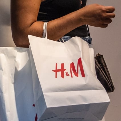 A shopper wearing a face mask carries an H&M branded shopping bag in Barcelona, Spain, in August. Photo: Bloomberg
