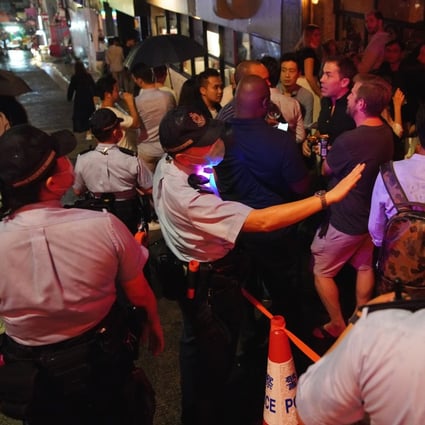 Police officers patrol a bar area in Central as patrons start to gather. Photo: Winson Wong