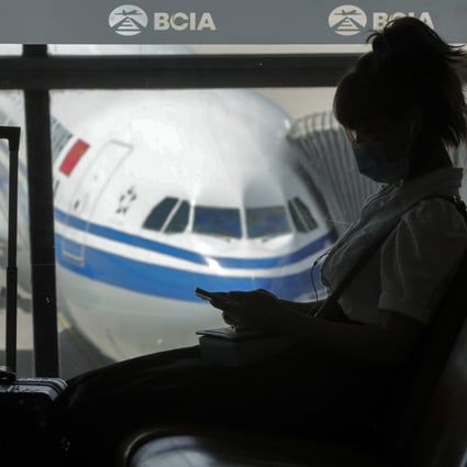 A woman wearing a face mask to help curb the spread of the coronavirus browses her smartphone at the Beijing Capital International Airport, on September 8, 2020. Photo: AP Photo