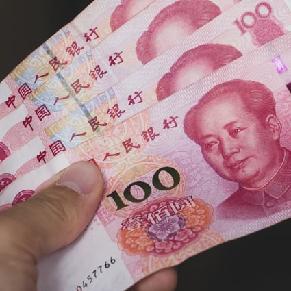 A person holds a stack of Chinese yuan bank notes. Photo: Shutterstock