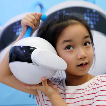 A girl plays with a robot designed to be a growing partner for kids at the 2018 Smart China Expo in Chongqing on August 23, 2018. Photo: Simon Song