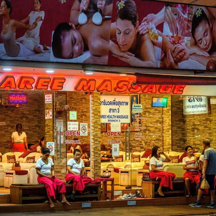 Employees waiting for customers outside a massage parlour in Pattaya. Photo: AFP