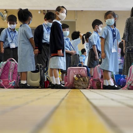 Children wait to have their temperatures checked at Yaumati Catholic Primary School (Hoi Wang Road). Photo: Winson Wong