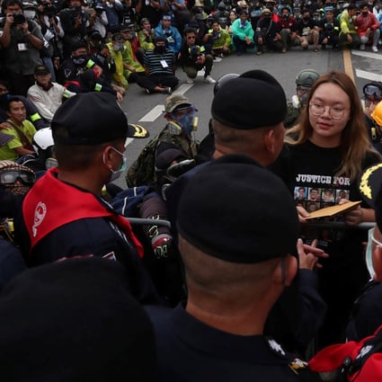 Student leader Panusaya Sithijirawattankul hands over a letter with demands for reforming the monarchy during a mass rally. Photo: Reuters