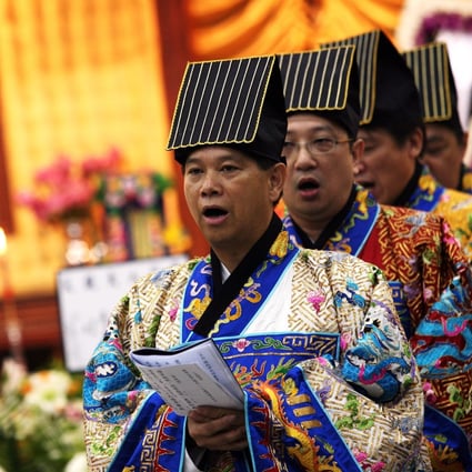 Taoist priests perform a unique ancient ritual for the funeral of Lo Keng-nin, former vice-chairman of religious charitable organisation Sik Sik Yuen, in Hong Kong on July 9, 2006. Photo: Martin Chan