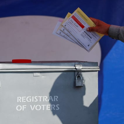 An election worker places mail-in ballots into a ballot box in San Diego, California, in 2018. File photo: AFP