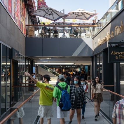 People wearing protective masks walk around a shopping area in Beijing in September 2020. China’s economic recovery from Covid-19 accelerated, spurred by a rebound in consumption. Photo: Bloomberg