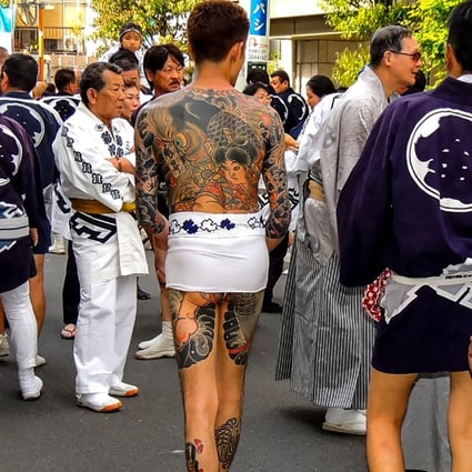 Yakuza gang members show their tattoos at a festival in Tokyo. In East Asia’s conservative societies, body art is associated with criminals, despite its embrace by young people. Photo: Shutterstock