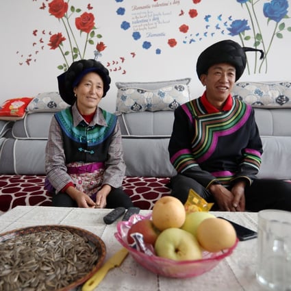 Jifu Jifuzi and his wife Li Youling watch TV in their new home. Photo: Simon Song