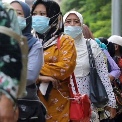 Malaysians line up at a bus stop in Kuala Lumpur. At least two politicians have tested positive as people took to social media to lambast them for violating social distancing protocols and refusing to self-isolate. Photo: Reuters