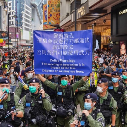 Police raise a blue warning flag on Great George Street in Causeway Bay. Photo: Sam Tsang