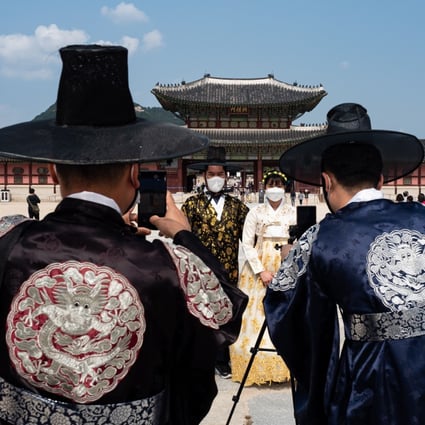 Filipino tourists wearing traditional Korean hanbok pose for photographs at the Gyeongbokgung Palace in Seoul on September 30. With Covid-19 going nowhere and widespread vaccines unlikely for another year, the imperative is to quickly establish protocols for safe travel. Photo: EPA-EFE