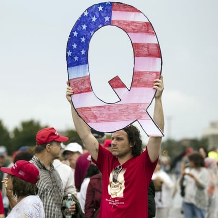 A protester holds a Q sign while waiting in line to enter a campaign rally with President Donald Trump in Pennsylvania. Photo: AP