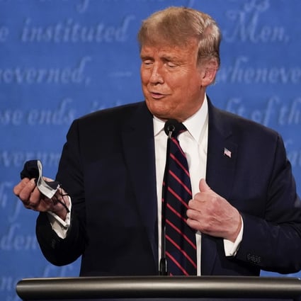 US President Donald Trump holds out his face mask during the first presidential debate on September 29. He tested positive for Covid-19 just days later. Photo: AP