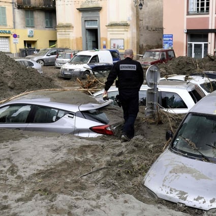 A police officer walks among vehicles submerged in mud in Breil-sur-Roya, south-eastern France, on Sunday. Photo: AFP