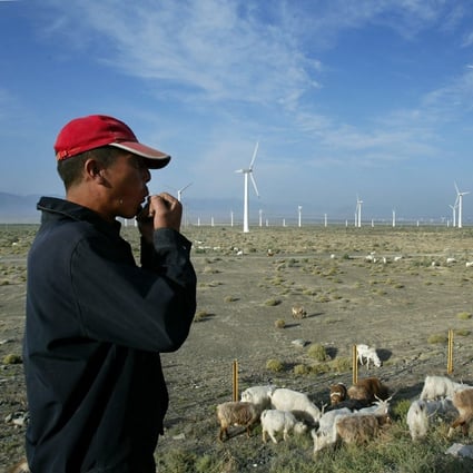 A sheep herder whistles as he follows his flock through a wind power farm outside Urumqi in September 2003, in western China’s Xinjiang Uygur autonomous region. Photo: AFP