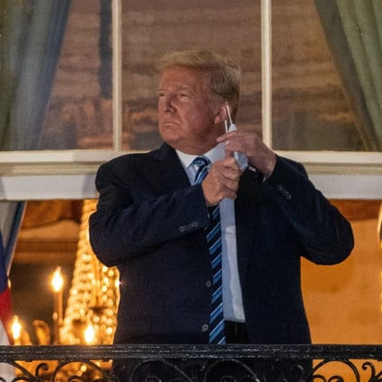 US President Donald Trump removes his protective mask at the White House , after his release from hospital. Photo: Bloomberg