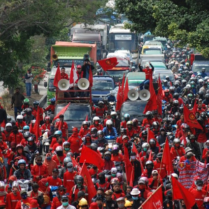 Workers in Bandung block a road during a strike against the newly enacted Omnibus Law. Photo: AFP