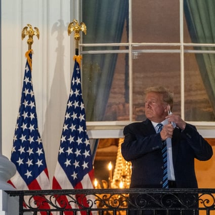 US President Donald Trump removes his protective mask on the Truman Balcony of the White House in Washington. Photo: Bloomberg