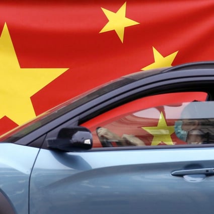 A woman wearing a face mask drives her car by a Chinese flag in Belgrade, Serbia in April. Photo: AP