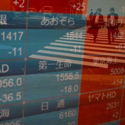 Passersby wearing protective face masks are reflected on a stock quotation board outside a brokerage in Tokyo, Japan. Photo: Reuters