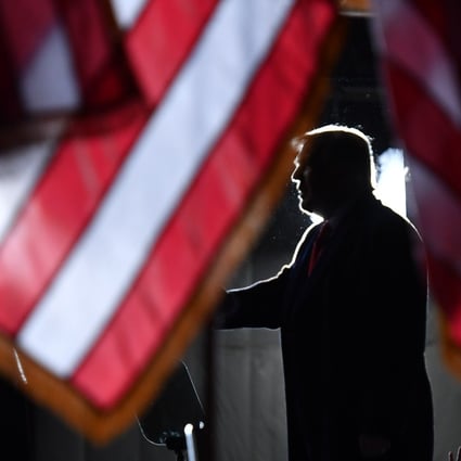 US President Donald Trump is seen behind US flags as he speaks to supporters at a “Great American Comeback” event in Mosinee, Wisconsin, on September 17. Photo: AFP