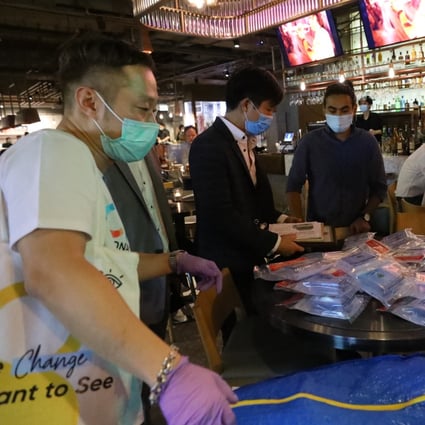Staff from the Hong Kong-based testing agency Prenetics visit Lan Kwai Fong to distribute Covid-19 test packs to bar patrons. Photo: Dickson Lee