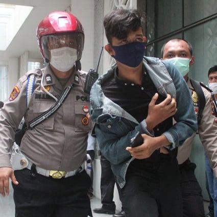 A young protester is detained by police officers in Medan on October 8, 2020. Photo: Tonggo Simangunsong