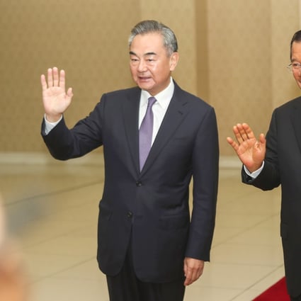 Chinese Foreign Minister Wang Yi (left} waves with Cambodian Prime Minister Hun Sen before a meeting at Peace Palace in Phnom Penh on Monday. Photo: AP