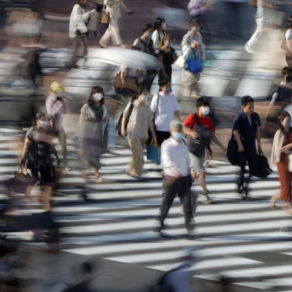 Pedestrians wearing face masks cross the road in Shibuya, Japan. Photo: EPA