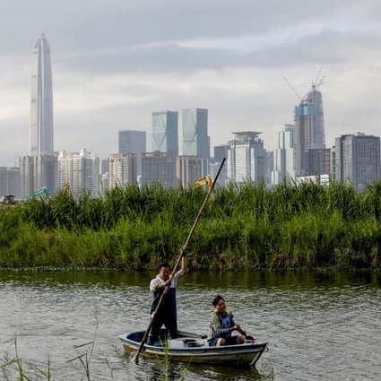 A fisherman returns to his home in Lok Ma Chau village, in Hong Kong, with the Shenzhen skyline visible in the distance. Photo: Reuters