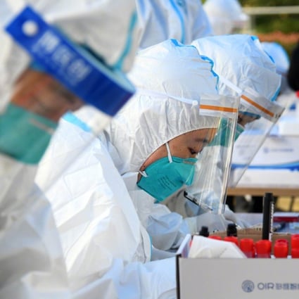 Medical staff collect Covid-19 samples near a residential area in Qingdao on Friday. Photo: Xinhua