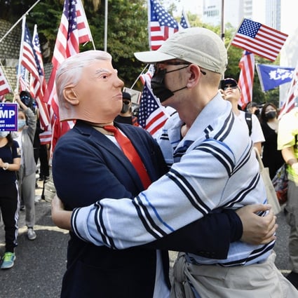 A protester embraces another wearing a Donald Trump mask during a pro-US rally in Central on December 1, 2019, after the American president signed the Hong Kong Human Rights and Democracy Act. Photo: Kyodo