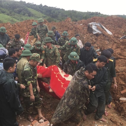Troops carry a body recovered from the landslide in Quang Tri province, Vietnam. Photo: AP