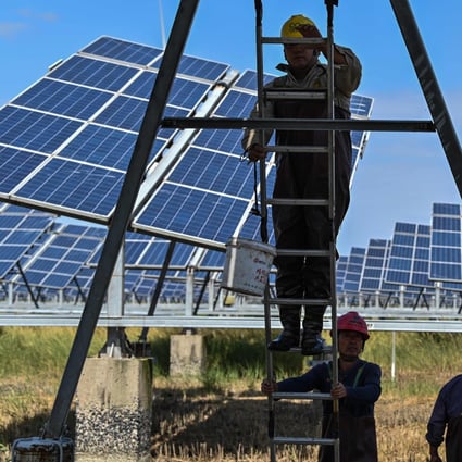 Workers work next to solar panels in an integrated power station in Yancheng city in Jiangsu province on October 14. Governments should consider focusing their support on public capital investment programmes, such as Infrastructure building, health facilities, education, and for the alleviation of climate change. Photo: AFP
