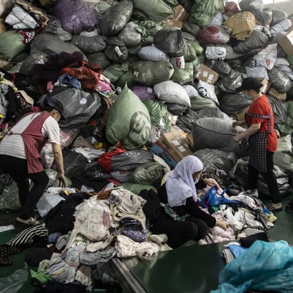 Employees sort used clothing at a facility operated by second-hand clothing trading firm Baijingyu in Hangzhou, China. Less than 1 per cent of the 26 million tonnes of clothing and accessories discarded each year in China is recycled or reused; the rest is exported, downcycled or burned. Photo: Bloomberg