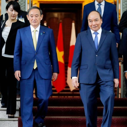Japan's Prime Minister Yoshihide Suga (centre left) and Vietnam's Prime Minister Nguyen Xuan Phuc (centre right) at the Government Office in Hanoi on October 19. Photo: AFP