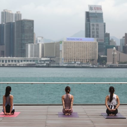 Yoga enthusiasts take their routine outdoors, at Tamar Park in Central on April 21. Photo: Winson Wong