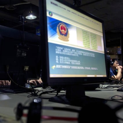 Computer users sit near a monitor display with a message from the Chinese police on the proper use of the internet at an internet cafe in Beijing. Photo: AP