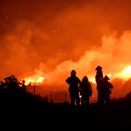 Los Angeles County firefighters keep watch on the Bobcat Fire as it burns through the night in Juniper Hills, California, on September 19. Spatial finance can improve the quality of predictions about the impact of climate change, allowing the financial sector to conduct a more accurate assessment of environmental risks. Photo: Reuters