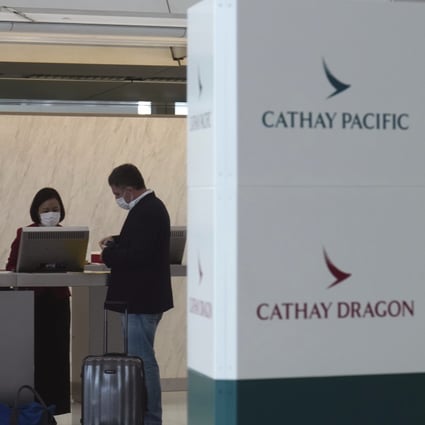 A passenger checks in at the Cathay Pacific counter at the Hong Kong International Airport, on Wednesday. The airline said it would cut 8,500 jobs and shut down its regional airline unit as part of a corporate restructuring. Photo: AP Photo