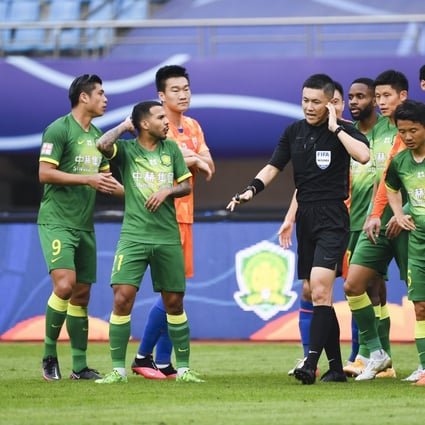 Referee Shen Yinhao (centre) reacts during the Chinese Super League match between Shandong Luneng and Beijing Guoan. Photo: Xinhua