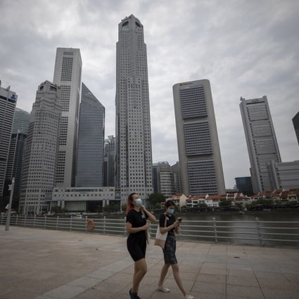 People walk past buildings in the Central Business District of Singapore earlier this month. Photo: EPA
