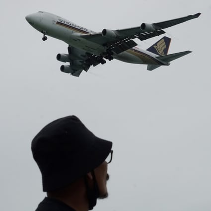A man looks on as a Singapore Airlines plane approaches for landing at Changi International Airport in Singapore. Photo: AFP