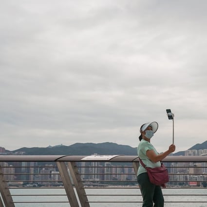 A woman takes selfies at Hong Kong’s waterfront in Tsim Sha Tsui. Photo: Felix Wong
