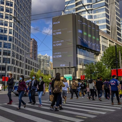 People cross the road as a screen shows the latest stock and currency data in Shanghai on October 8. Many in the currency markets believe the yuan has entered a period of secular advance and that Beijing can afford to relax capital controls. Photo: EPA-EFE