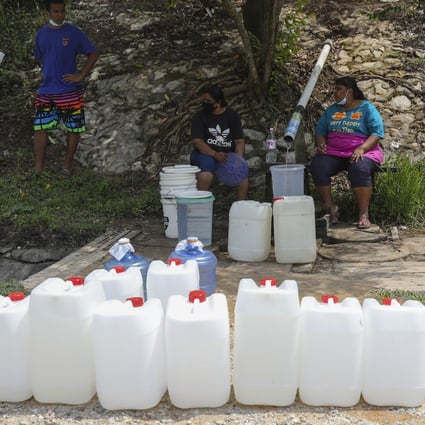 Malaysians wait to refill their containers from the natural springs in Shah Alam outside Kuala Lumpur after water supply was affected by the closure of treatment plants in Selangor river. Photo: EPA-EFE
