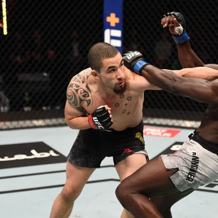 Robert Whittaker punches Jared Cannonier in their middleweight bout at UFC 254 on Fight Island in Abu Dhabi. Photos: Josh Hedges/Zuffa LLC via Getty Images