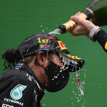 Lewis Hamilton is sprayed with champagne at the podium by fellow Mercedes driver Valtteri Bottas after the Formula One Portuguese Grand Prix at the Algarve International Circuit in Portimao on Sunday. Photo: AP