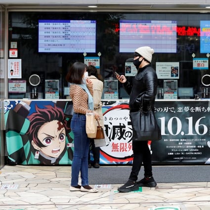 A couple outside a Tokyo cinema waiting to purchase tickets for Demon Slayer. Photo: Reuters